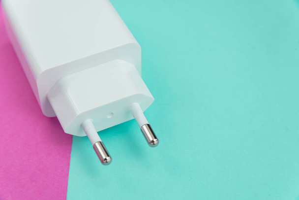 Зарядное устройство и USB кабель типа C на розовом и синем фоне - Фото, изображение