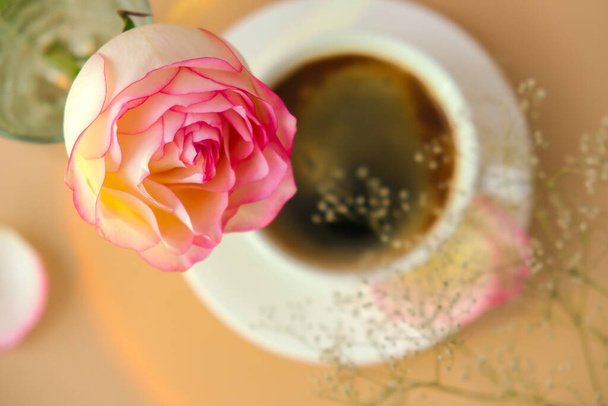 Rosa tierna sobre jarrón con taza de café blanco sobre fondo beige. Composición mínima. Romántica flor rosa pastel. Estética moderna. Tonos neutros de tierra. Vacaciones desayuno por la mañana Hardlight - Foto, imagen