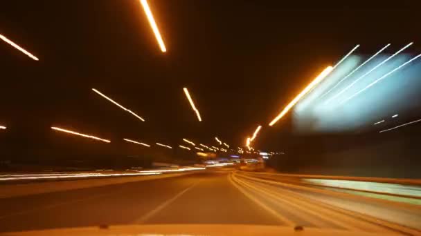 8K 7680x4320 4320p.Éjszakai lámpák és forgalom a városi utakon.Lassú zsalugáter belülről pilótafülkében.Az autó sötétben mozog.Jármű fényszórók.Bokeh hatás és városi fények.Nagy sebességű út. - Felvétel, videó
