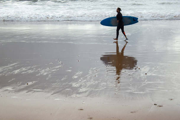 Homem de cabelos escuros treinando na praia sozinho - Foto, Imagem