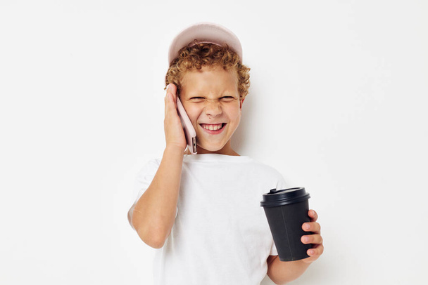söpö poika valkoinen t-paita korkki puhelin lasi juoma elämäntapa muuttamaton - Valokuva, kuva