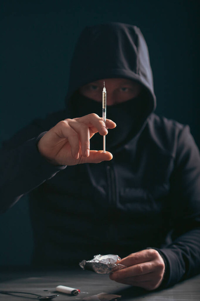 Addict/junkie man preparing drugs. The concept of crime and drug addiction. - Foto, Bild