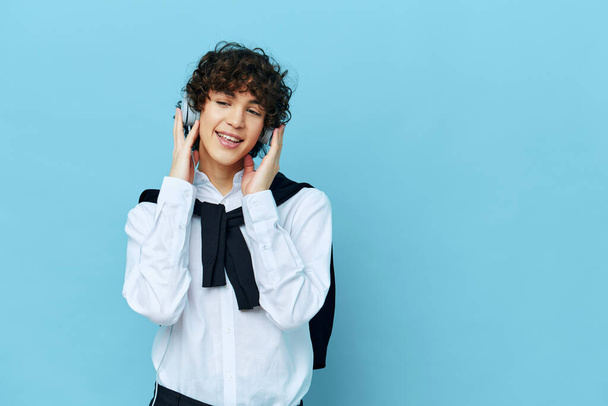 curly guy listens song in headphones entertainment blue background - Photo, Image