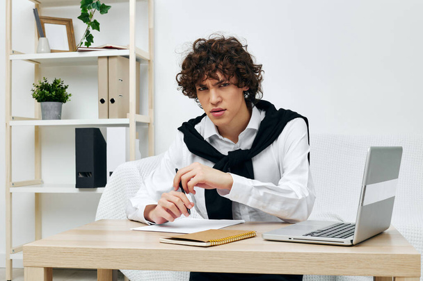 curly guy laptop sitting on white sofa online training communication - Фото, изображение