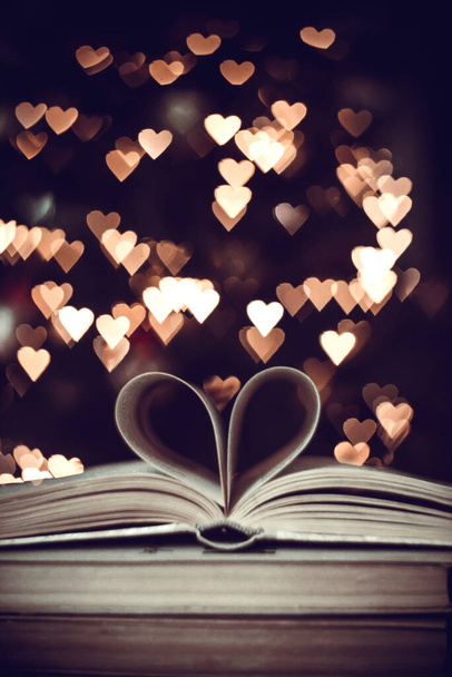 Livre en papier en forme de cœur sur le fond des cœurs bokeh. Saint Valentin concept.love symbole  - Photo, image