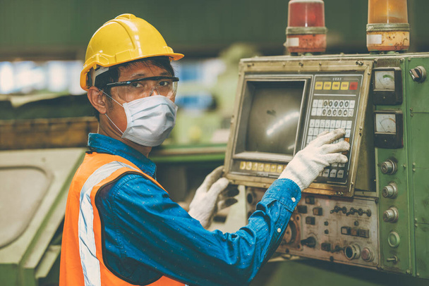 アジアの労働者は、健康のために工場でコロナウイルス拡散や煙塵大気汚染フィルターを保護するための使い捨てフェイスマスクを着用. - 写真・画像