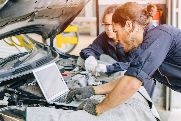 Meachnic zaměstnanců pomocí notebooku zkontrolovat ane tuning auto motor v garáži - Fotografie, Obrázek