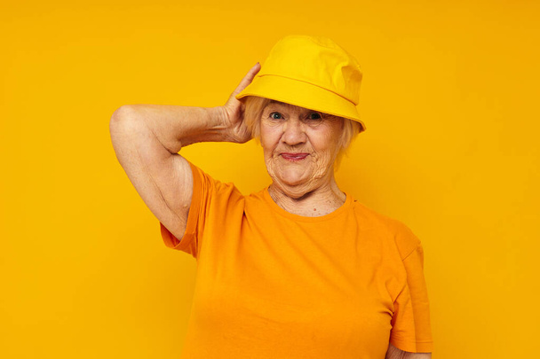 smiling elderly woman happy lifestyle in a yellow headdress yellow background - Photo, Image