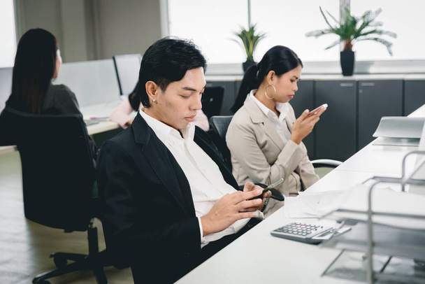 Ofis çalışanı iş yerinde akıllı telefon oynuyor ve sosyal medya şirket sorunları için kötü alışkanlık haline geldi. - Fotoğraf, Görsel