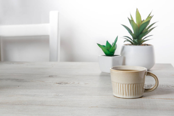 Office desk wood table of the business work place, artificial plants and coffee cup with copy space on grey wooden table. - Photo, Image