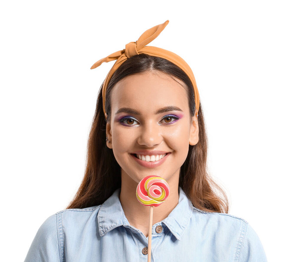Beautiful young woman with sweet lollipop on white background - Photo, Image
