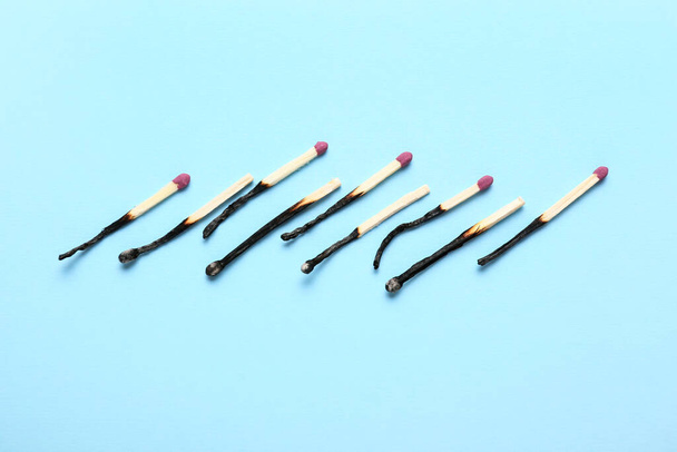 Row of burnt matches on color background. Concept of work burnout - Photo, Image