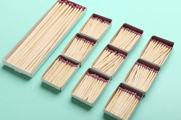 Caixas diferentes com matchsticks de madeira inteira no fundo de cor, close-up. Conceito de liderança - Foto, Imagem