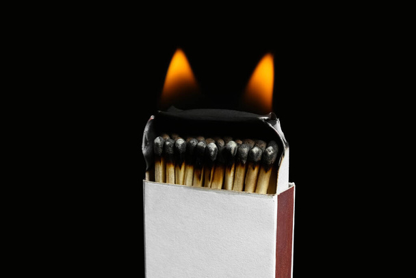 Burning box with matches on black background. Concept of work burnout - Photo, Image