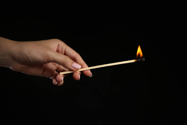 Mão feminina com lareira em chamas jogo no fundo preto - Foto, Imagem