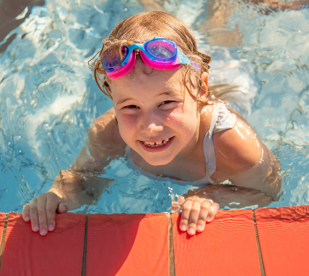 Joyful child at edge of swimming pool in summer - Photo, Image