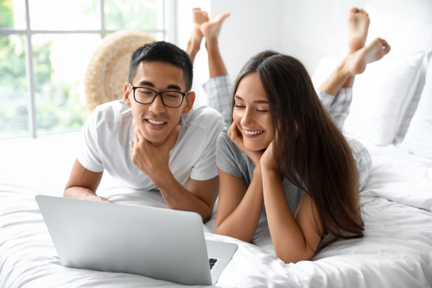 junges Paar benutzt Laptop im Schlafzimmer - Foto, Bild