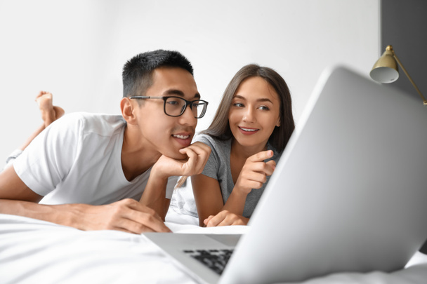 Casal jovem usando laptop no quarto
 - Foto, Imagem