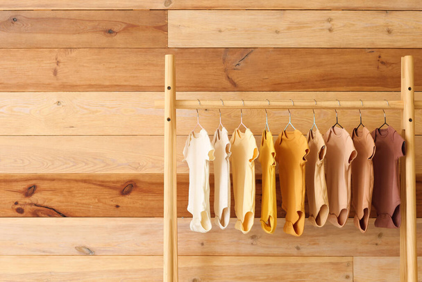 Підставка з дитячими костюмами біля дерев'яної стіни
 - Фото, зображення