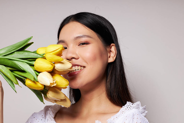 Portret aziatische mooie jonge vrouw bloemen lente poseren licht achtergrond ongewijzigd - Foto, afbeelding