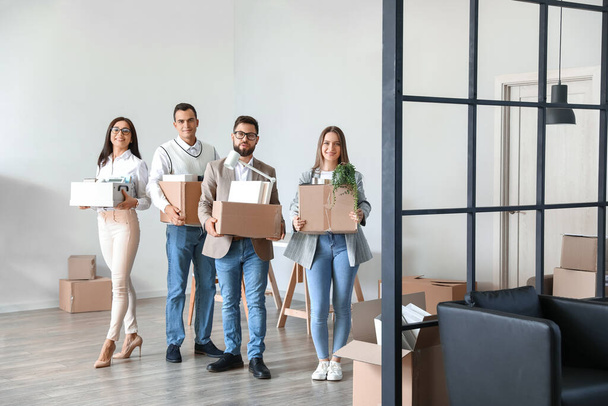 Деловые люди держат коробки с вещами в офисе в день переезда - Фото, изображение