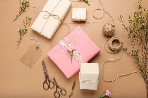 Beautiful composition with gift boxes and set for packing on color wooden background - Photo, Image