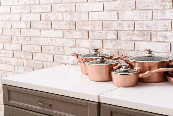 Ensemble d'ustensiles de cuisine sur le comptoir près du mur de briques claires - Photo, image