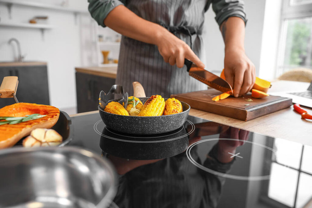 Poêle à frire avec du maïs savoureux sur la cuisinière dans la cuisine, gros plan - Photo, image