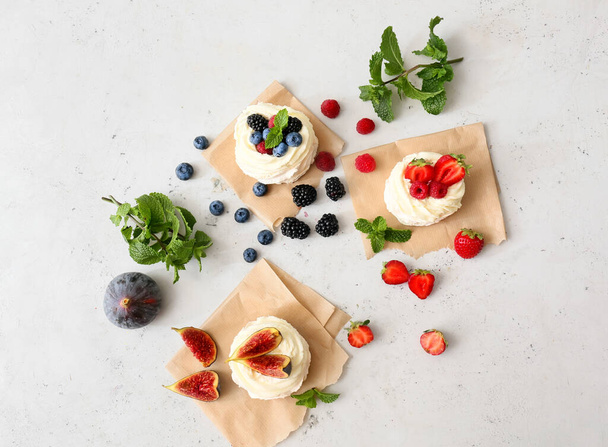 Sabrosos pasteles Pavlova con frutas sobre fondo claro - Foto, imagen