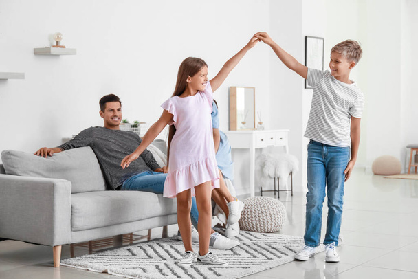Onnellinen pari ja heidän tanssivat lapsensa kotona - Valokuva, kuva