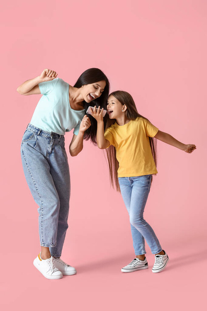 gelukkig dansen vrouw en haar dochter op kleur achtergrond - Foto, afbeelding