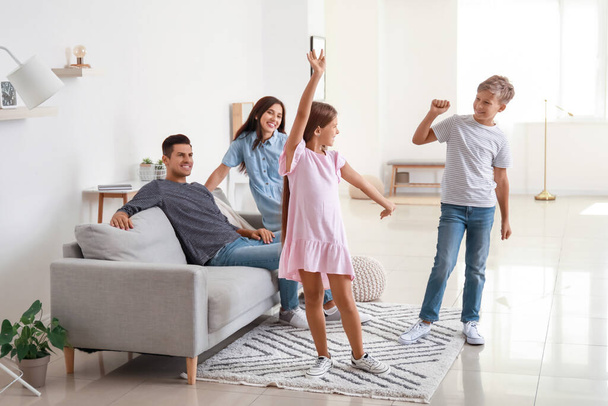 Happy couple and their dancing children at home - Photo, Image