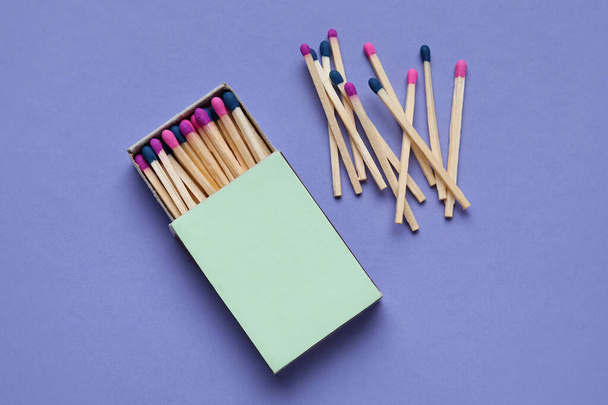 Коробка с различными новыми спичками на фиолетовом фоне - Фото, изображение