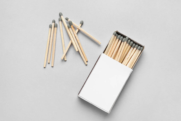 Box with new matchsticks on grey background - Fotoğraf, Görsel