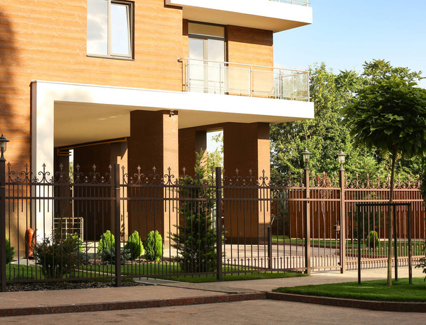 View of beautiful landscape design with fence near modern building in city - Foto, immagini