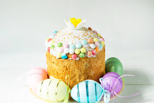 Easter cake with painted eggs on a platter in a gray interior. Traditional festive food - Fotoğraf, Görsel