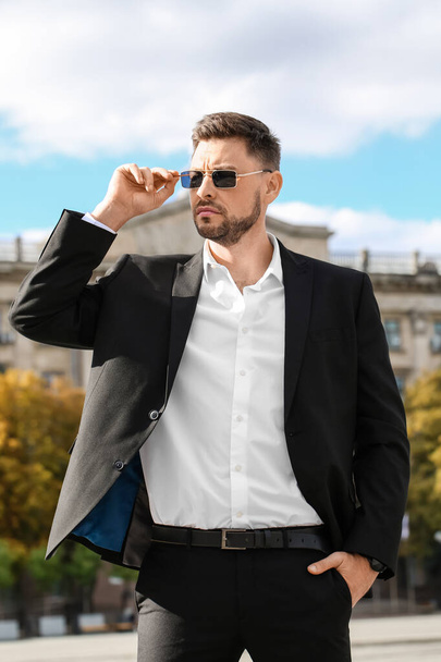 Stylish businessman in sunglasses on city square - Photo, Image