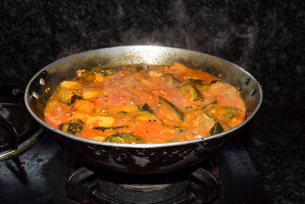 Mieszać ziemniaki i sos brinjal indyjski styl curry gotowane na gazowej płycie grzewczej w Kadahi lub kotle karahi - Zdjęcie, obraz