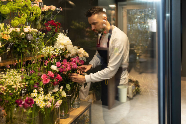 kukkakauppias kerää ylellinen kukkakimppu tuoreita kukkia jääkaapissa - Valokuva, kuva