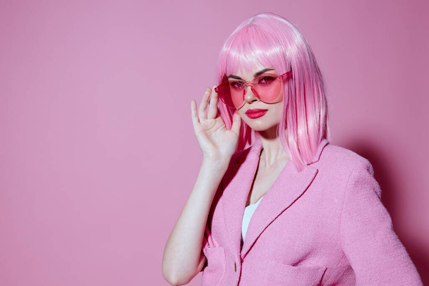 Portrait of a charming lady gesturing with hands pink jacket lifestyle glamor pink background unaltered - Foto, Imagem