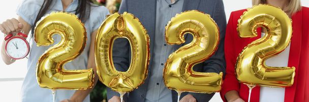 Group of business people holding golden helium balloons with numbers 2022 and alarm clock - Photo, Image