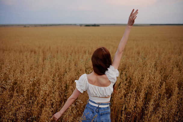 žena se zvednutou rukou v poli příroda svoboda léto - Fotografie, Obrázek
