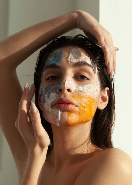 portrait d'une belle fille avec un masque pour nettoyer la peau sur son visage - Photo, image