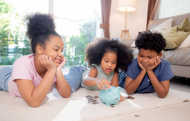 Bonheur Famille africaine avec enfants économiser de l'argent dans une tirelire pour planifier l'avenir des dépenses pour le succès financier, le dépôt et l'investissement, la vie domestique, les affaires et la finance concept. - Photo, image