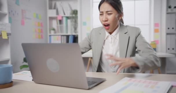 Młoda azjatycka bizneswoman siedząca na biurku szalona z przepracowanym stresem wściekła masywna praca krzyczy w biurze. Pani szalone kłopoty z pracy od pracownika sprawiają, że nie raport finansów pracy, Zdrowie psychiczne pracy. - Materiał filmowy, wideo
