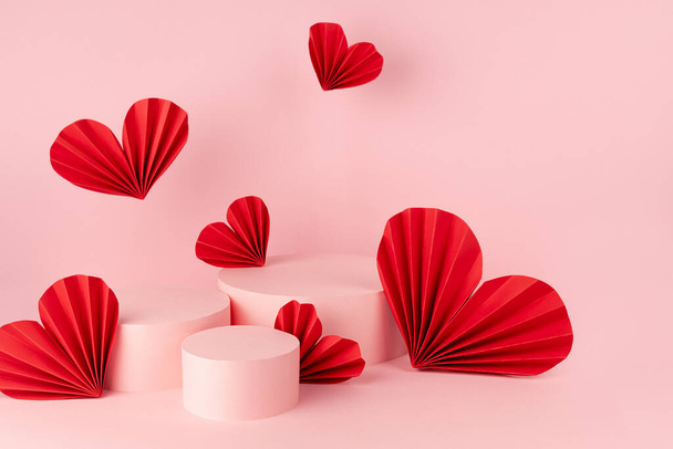 Tender pastel pink stage mockup with three round podiums, fly passion red paper hearts of asian fans in chinese style, copy space. Scene template for advertising, presentation cosmetic, design. - Foto, afbeelding