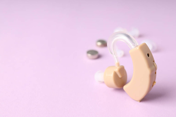 Az egészségügyi ellátás fogalma hallókészülékkel lila alapon - Fotó, kép