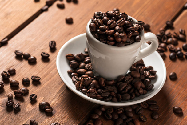 Grains de café torréfiés dans une tasse
  - Photo, image