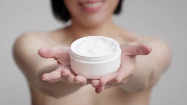 Unrecognizable Mature Asian Woman Holding Moisturizer Jar Over Gray Background - Footage, Video