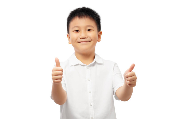 Happy kid giving thumps up wearing white shirt isolated on white background - Photo, Image
